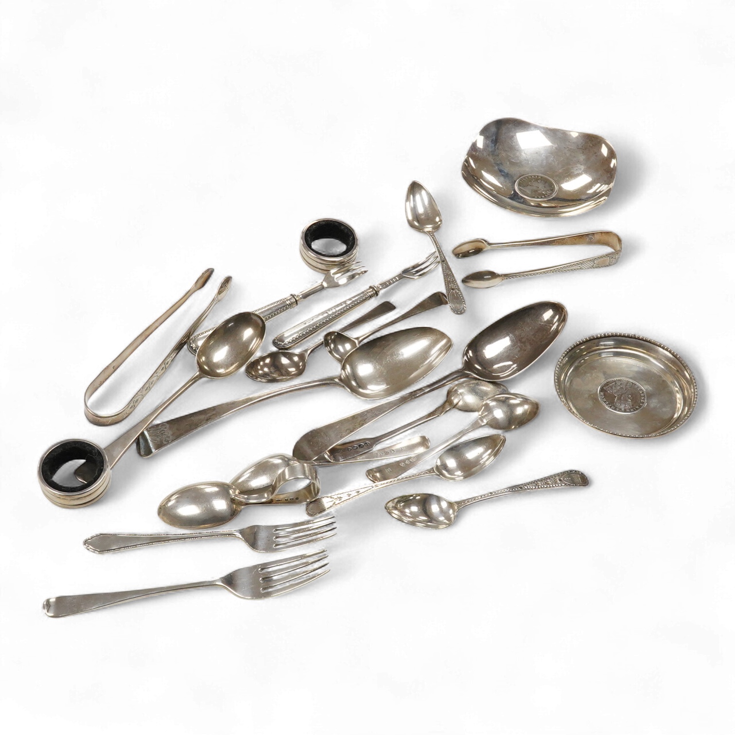 A collection of small silver and white metal items, including an Indian Hamilton & Co small dish, the centre inset with 1840 one rupee coin, one other white metal dish, two modern silver mounted napkin rings, fourteen as